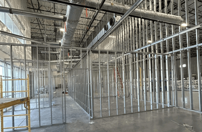 drywall-wall-sanding.png Drywall professional sanding walls to achieve a smooth finish.